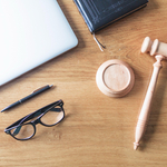 High-angle-view-of-laptop-spectacles-gavel-and-pen-on-wooden-background-on-wooden-desk